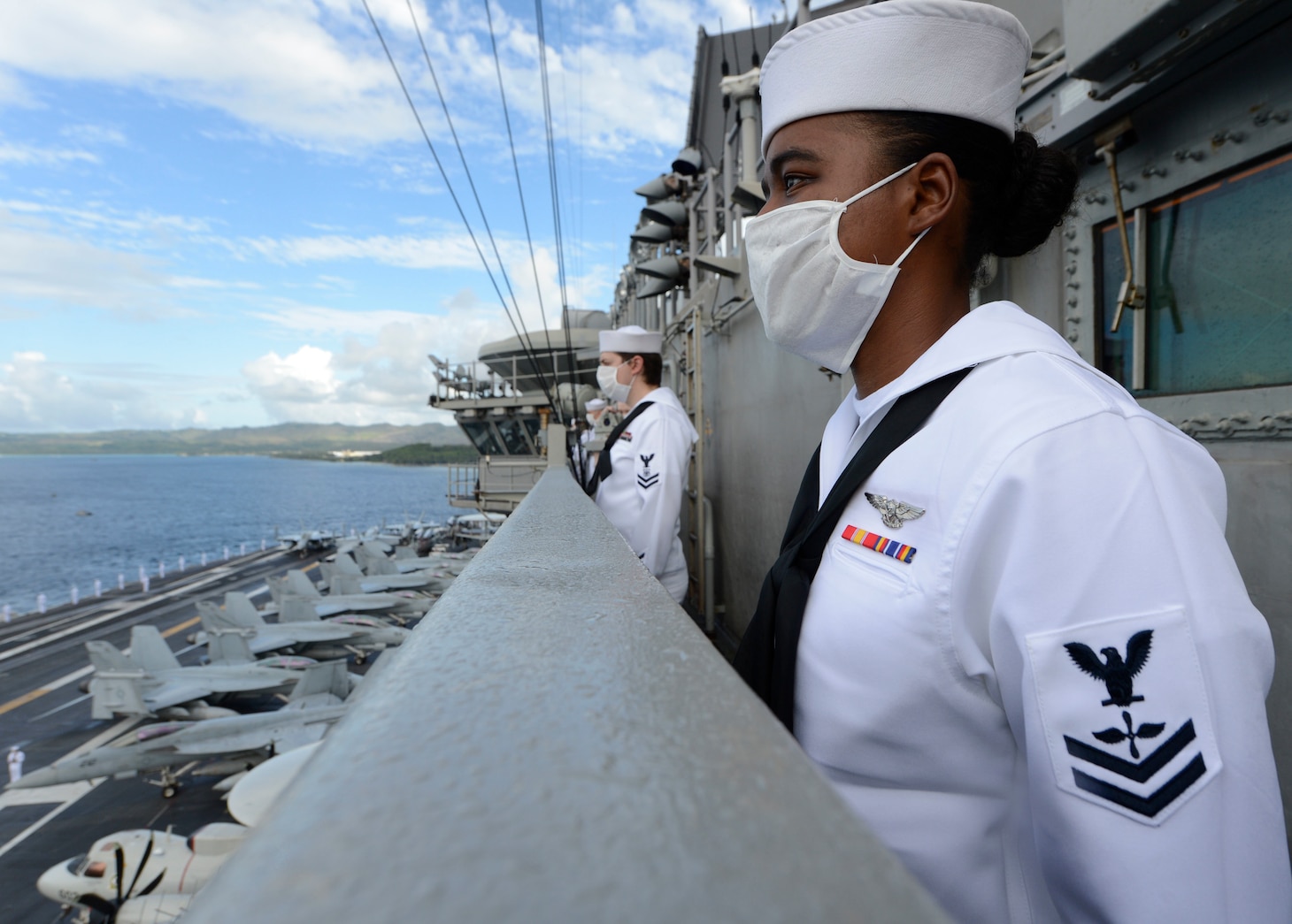 APRA HARBOR (June 4, 2020) – U.S. Navy Aviation Machinist’s Mate 2nd Class Sheila Ferreira, from New Bedford, Mass., mans the rails as the aircraft carrier USS Theodore Roosevelt (CVN 71) departs Apra Harbor July 4, 2020. Following an extended visit to Guam in the midst of the COVID-19 global pandemic, Theodore Roosevelt is returning to operational tasking during a deployment to the Indo-Pacific.