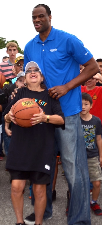 Tall man poses for a photo with kids.
