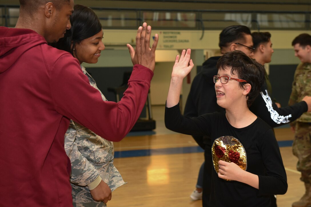 Child and adult share a high-five.