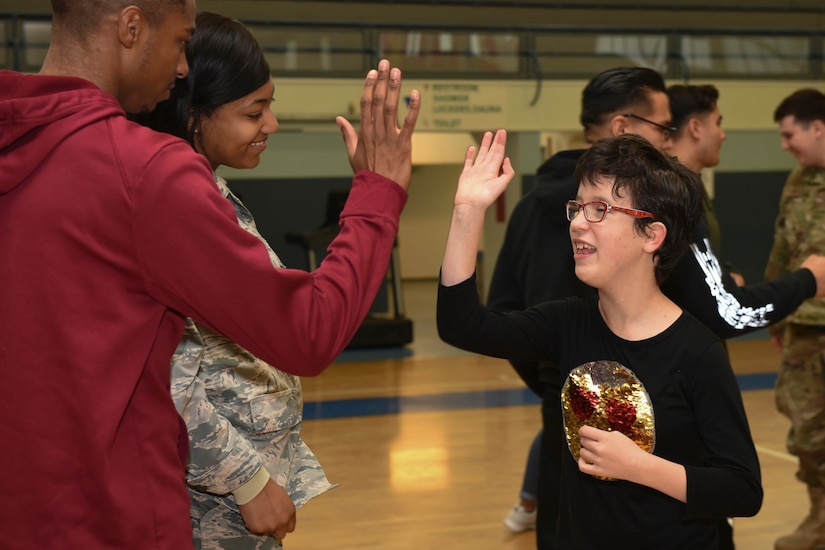 Child and adult share a high-five.