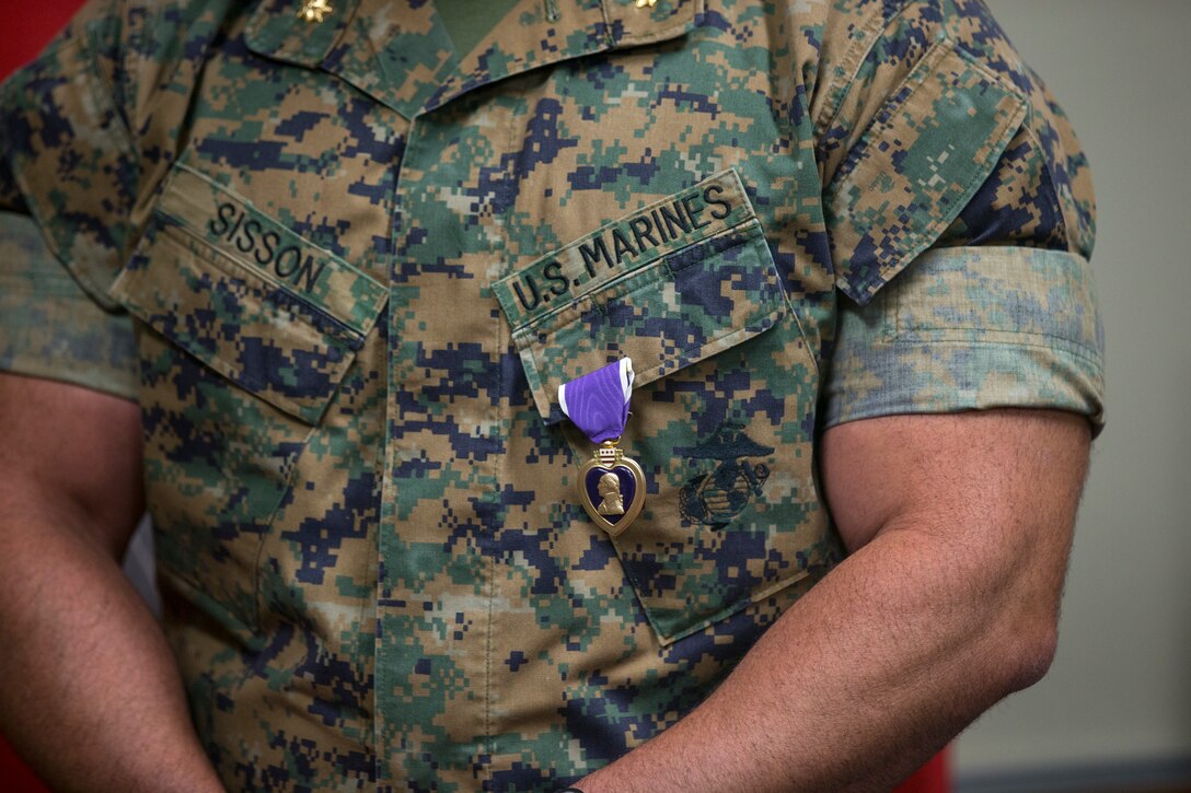 U.S. Marine Corps Maj. Craig Sisson with Marine Corps Air Station (MCAS) Yuma, receives a Purple Heart from Col. David A. Suggs, commanding officer, MCAS Yuma, at the MCAS Yuma Headquarters building, June 1, 2020.