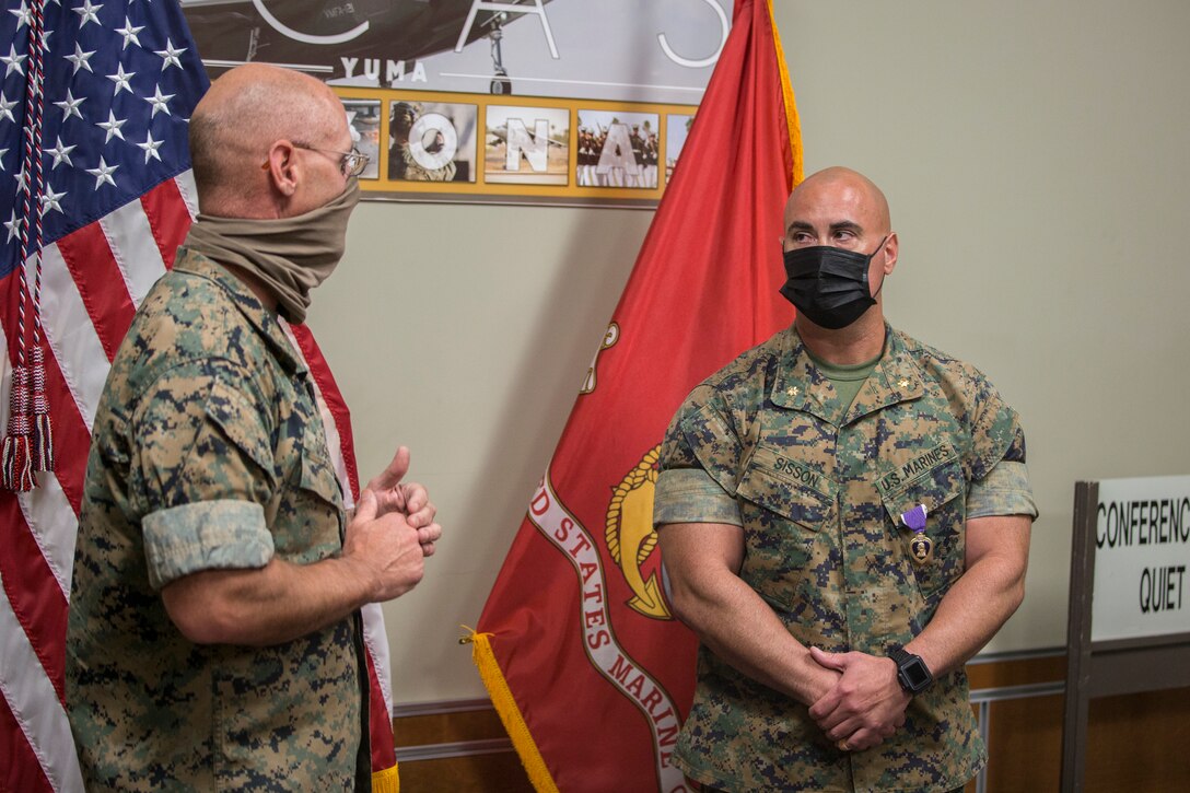 U.S. Marine Corps Maj. Craig Sisson with Marine Corps Air Station (MCAS) Yuma, receives a Purple Heart from Col. David A. Suggs, commanding officer, MCAS Yuma, at the MCAS Yuma Headquarters building, June 1, 2020.