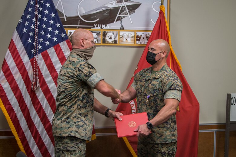 U.S. Marine Corps Maj. Craig Sisson with Marine Corps Air Station (MCAS) Yuma, receives a Purple Heart from Col. David A. Suggs, commanding officer, MCAS Yuma, at the MCAS Yuma Headquarters building, June 1, 2020. Maj. Sisson received the Purple Heart for wounds sustained while deployed in support of Operation Enduring Freedom on May 13, 2013. (U.S. Marine Corps photo by Lance Cpl John Hall)