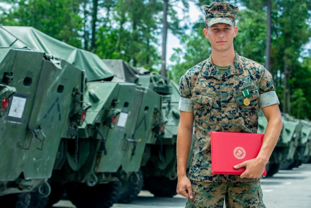 U.S. Marine Corps Cpl. Matthew T. Ubl, a light armored vehicle repair technician with Alpha Company (Co.), 2d Light Armored Reconnaissance Battalion (LAR), 2d Marine Division (MARDIV), salutes Lt. Col. Christopher Conner, the commanding officer for Alpha Co., 2d LAR, on Camp Lejeune, North Carolina, June 4, 2020. Ubl received a Navy and Marine Corps Commendation Medal for his efforts executing cardiopulmonary resuscitation (CPR) for 15 minutes on an unknown, unconscious civilian, which contributed to saving the man’s life. (U.S. Marine Corps photo by Sgt. Stormy Mendez)