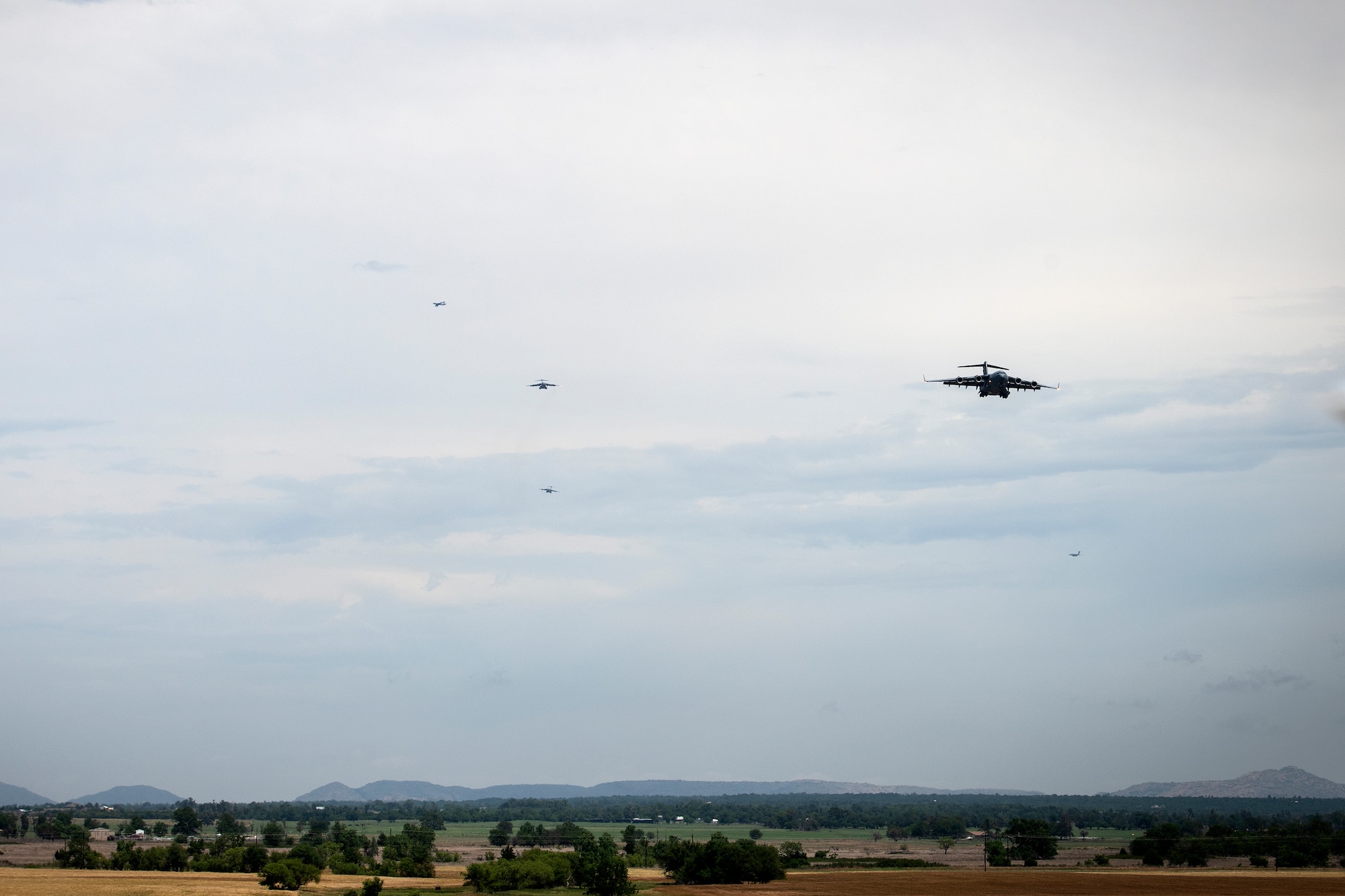 A formation of U.S. Air Force C-17 Globemaster IIIs approach the runway at Altus Air Force Base, Oklahoma, during a large formation exercise, May 21, 2020.