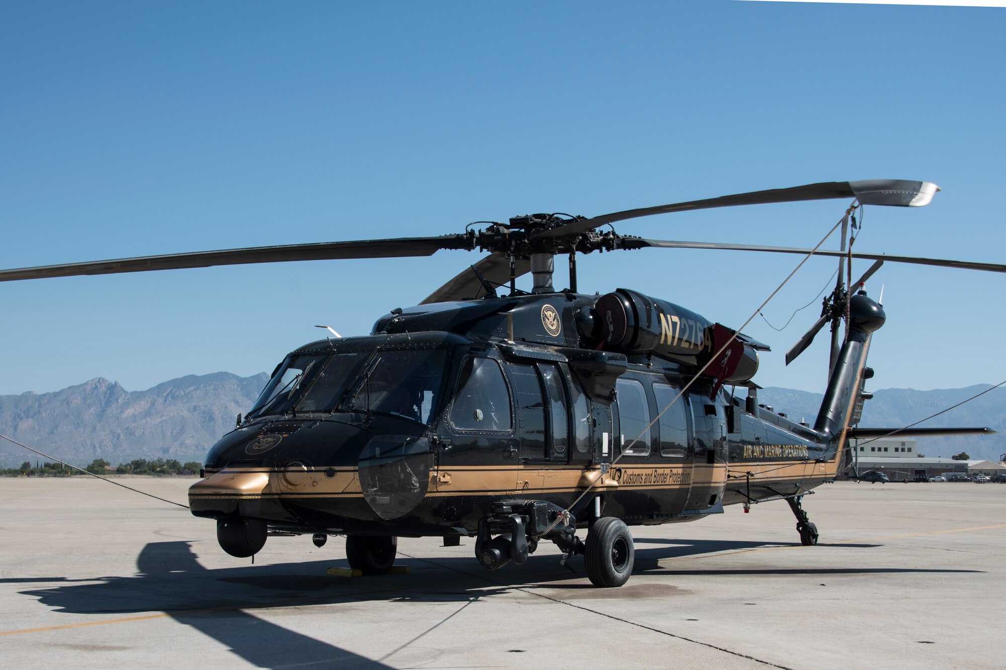 A photo of a CBP helicopter sitting on the flight line.
