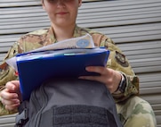 Senior Airman Allison Payne, 628th Air Base Wing Public Affairs photojournalist, looks over papers before departing on a deployment at Joint Base Charleston S.C., May 31, 2020. Deployments are necessary for military members in order to ensure rapid global mobility for whenever an operation is needed to be carried out; furthermore, deployments are an opportunity for military members to expand their knowledge and work in different environments