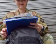 Senior Airman Allison Payne, 628th Air Base Wing Public Affairs photojournalist, looks over papers before departing on a deployment at Joint Base Charleston S.C., May 31, 2020. Deployments are necessary for military members in order to ensure rapid global mobility for whenever an operation is needed to be carried out; furthermore, deployments are an opportunity for military members to expand their knowledge and work in different environments