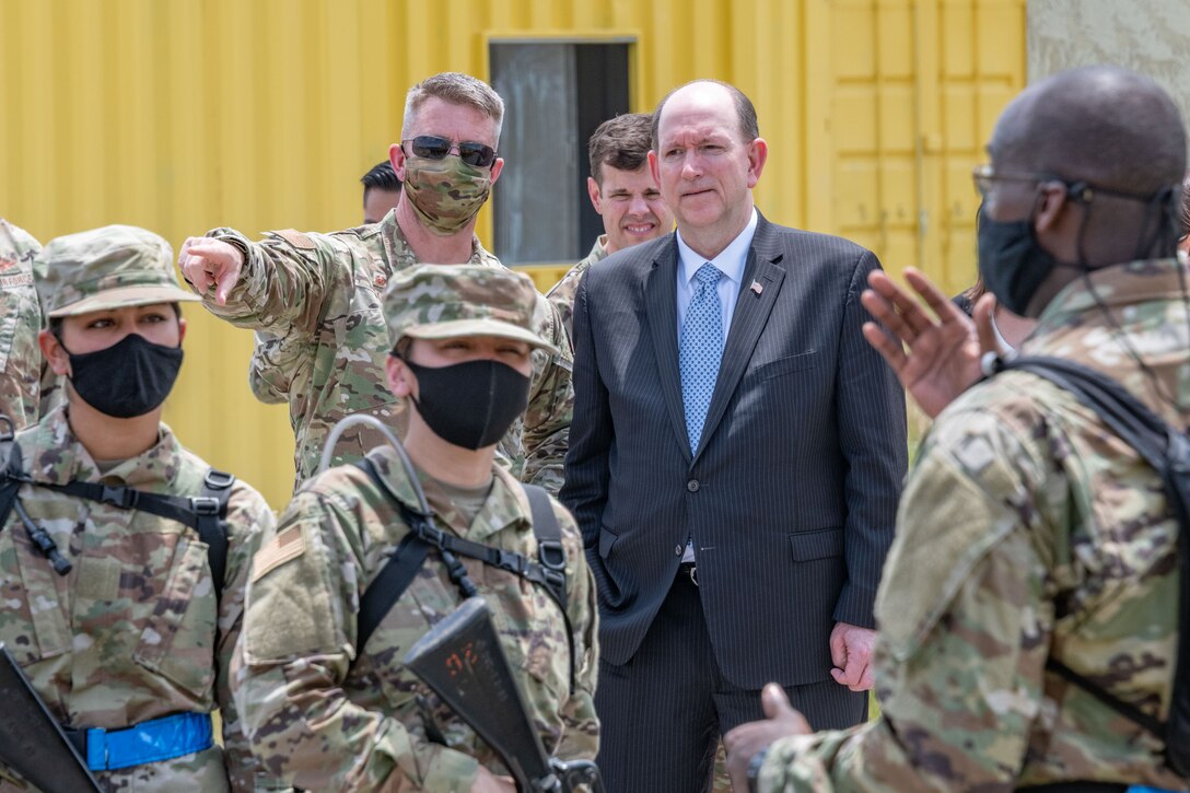 Col. Jayson Allen, commander of Officer Training School, and Matthew Donovan, Under Secretary of Defense for Personnel and Readiness, observe as the officer trainees complete expeditionary skills training.