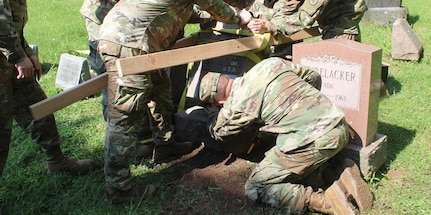 New York Army National Guard Soldiers assigned to the Headquarters Company of the 2nd Battalion, 108th Infantry, work on May 26, 2020, to repair the headstone of Pvt. Laurence Uebelacker. Uebelacker was killed during World War I while storming the Hindenburg Line as part of the 108th Infantry.