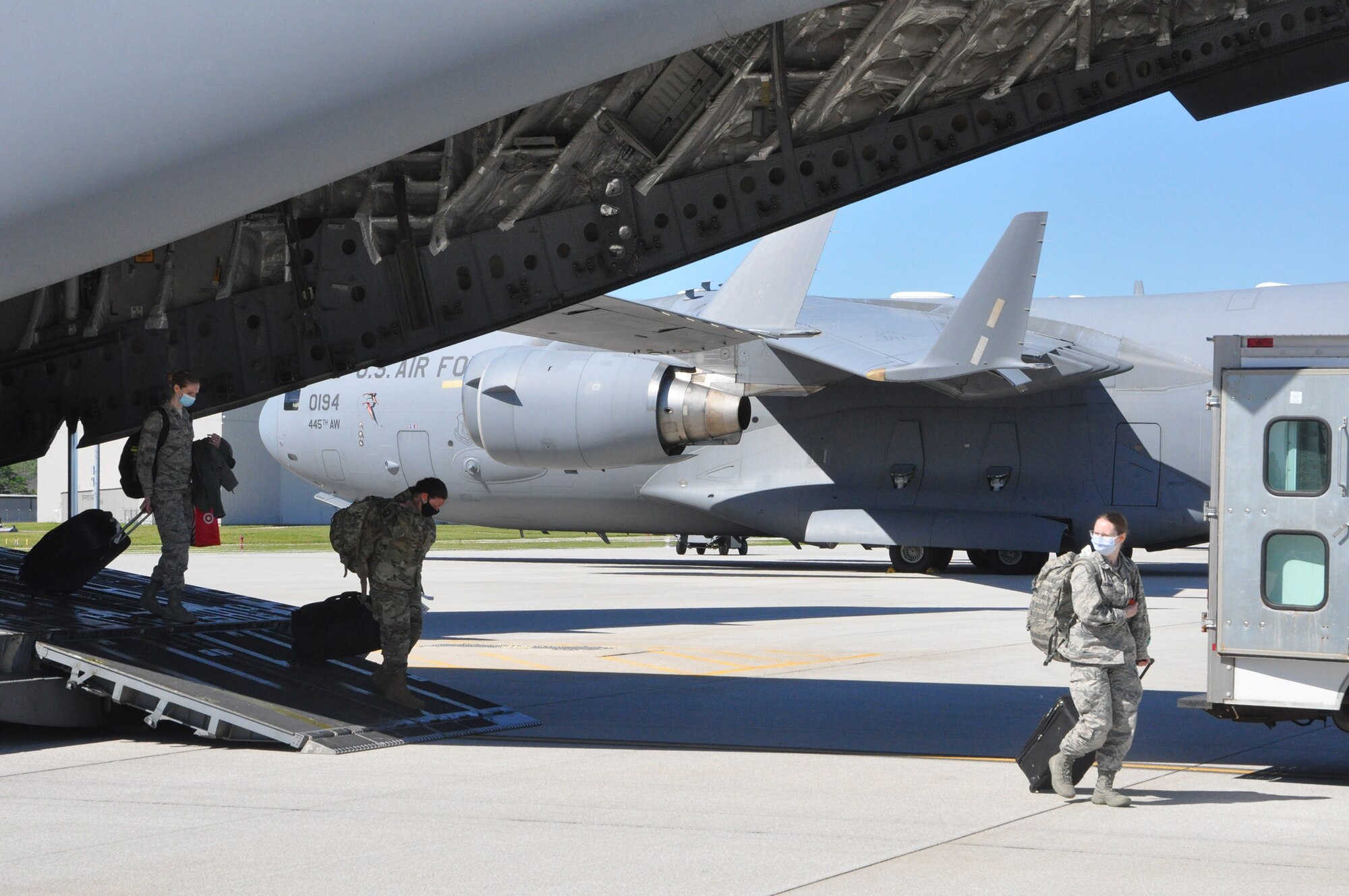 Airmen from the 445th Aeromedical Staging Squadron return home here May 31, 2020, after arriving on a 445th Airlift Wing C-17 Globemaster III. The medical reservists departed to serve on the front line of COVID-19 in New York City, New York in early April, 2020. The group partnered with civilian and military counterparts to support the Lincoln Medical Center in The Bronx, New York during the pandemic. (U.S. Air Force photo/Lt. Col. Cynthia Harris)