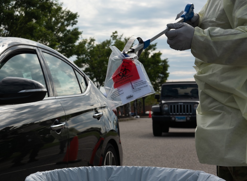 A U.S. Air Force Airman collects a sample during a mass rapid oral fluid COVID-19 test process at Joint Base Langley-Eustis, Virginia, June 2, 2020. JBLE’s efforts align with the Center for Disease Control and Prevention, White House and DoD testing recommendations and will also help the community understand the prevalence of asymptomatic cases in this sample population. (U.S. Air Force photo by Airman 1st Class Sara Dowe)