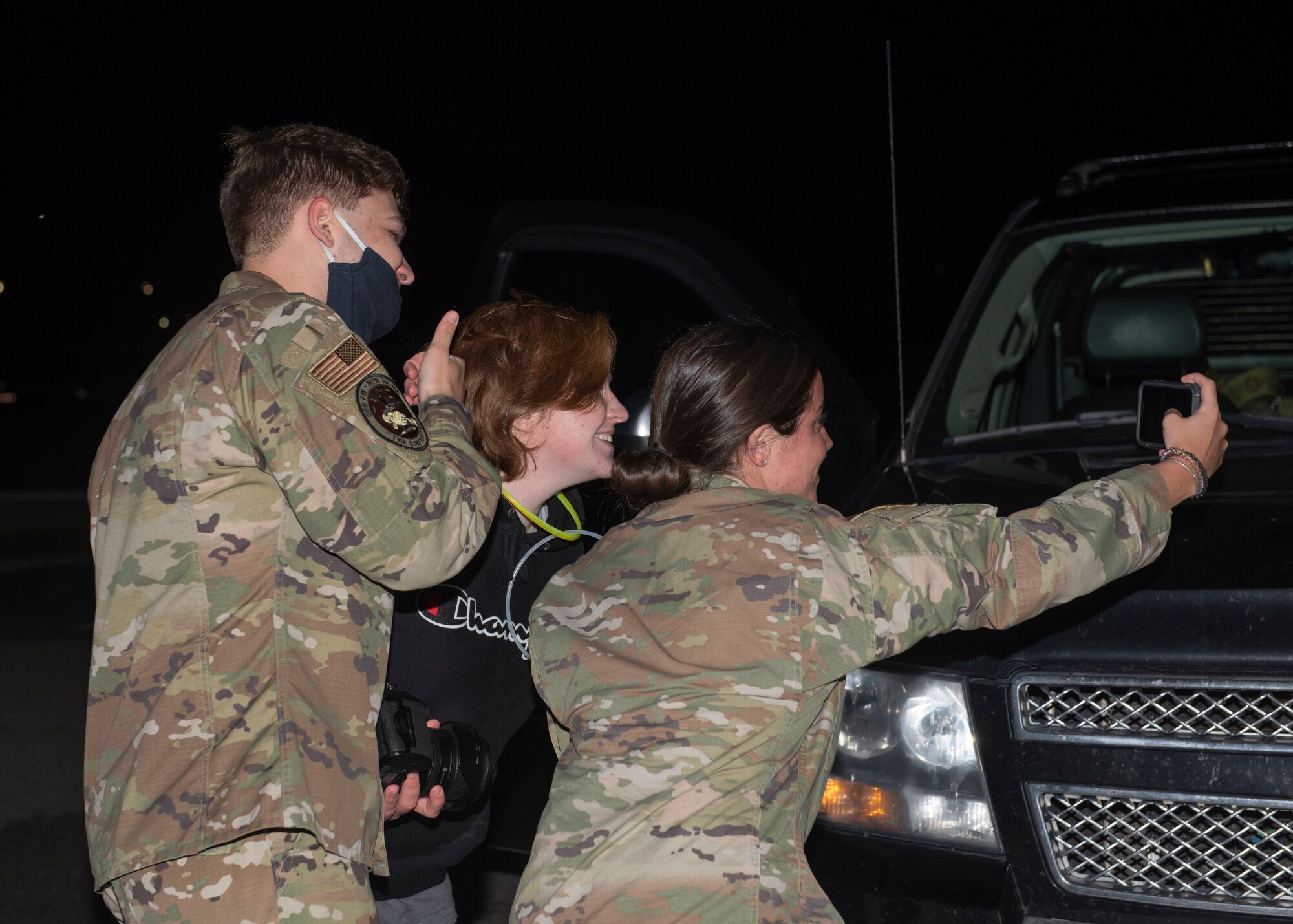 U.S. Air Force Airman 1st Class Nicholas Swift (left), 366th Fighter Wing broadcast journalist, Senior Airman Savannah Irwin (middle), 366th Munitions Squadron armaments back shop, and Airman 1st Class Barbara Miller, 726th Air Control Squadron surveillance technician, take a photo, May 21, 2020, at Mountain Home Air Force Base, Idaho. Miller was greeted by her friends when she returned from an eight month long deployment. (U.S. Air Force photo by Airman 1st Class Natalie Rubenak)