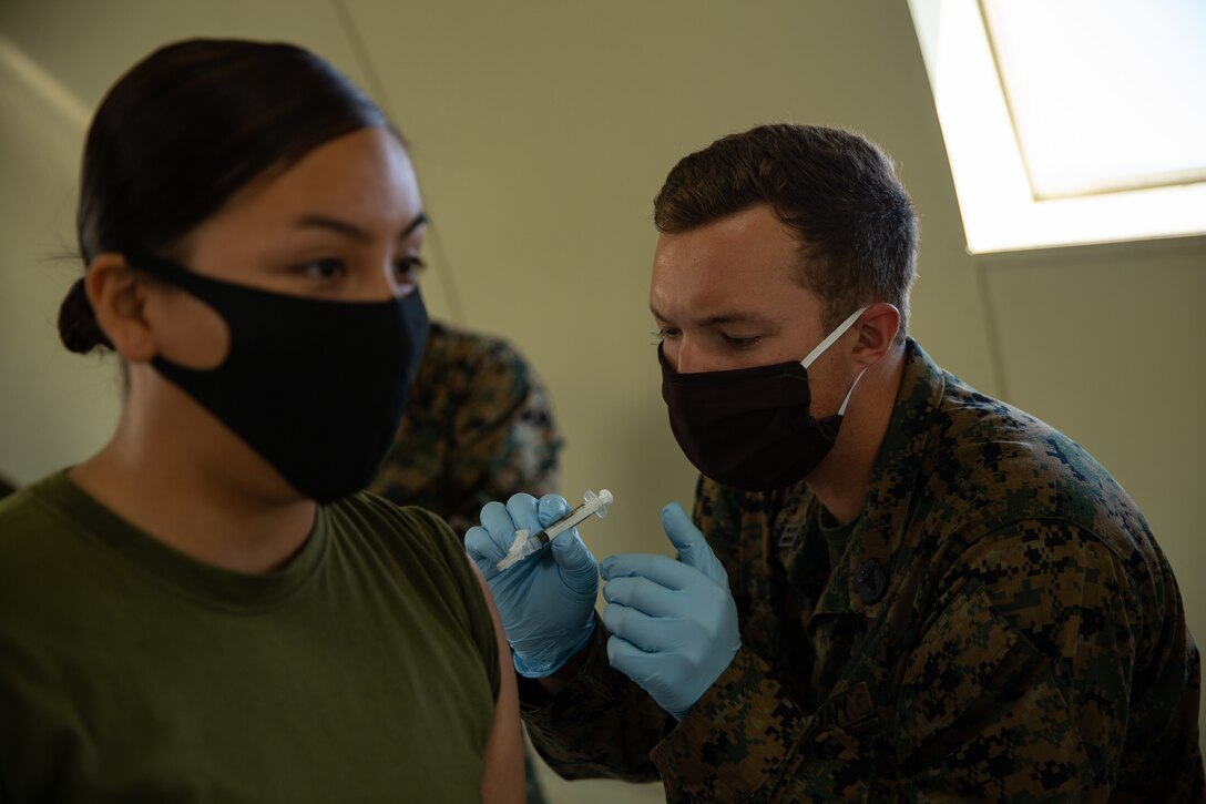 .S. Navy Seaman Jared Doherty, a hospitalman with Battalion Landing Team 1/4, 15th Marine Expeditionary Unit, administers a vaccine to a Marine with the 15th MEU during a shot exercise at Marine Corps Base Camp Pendleton, June 3, 2020.