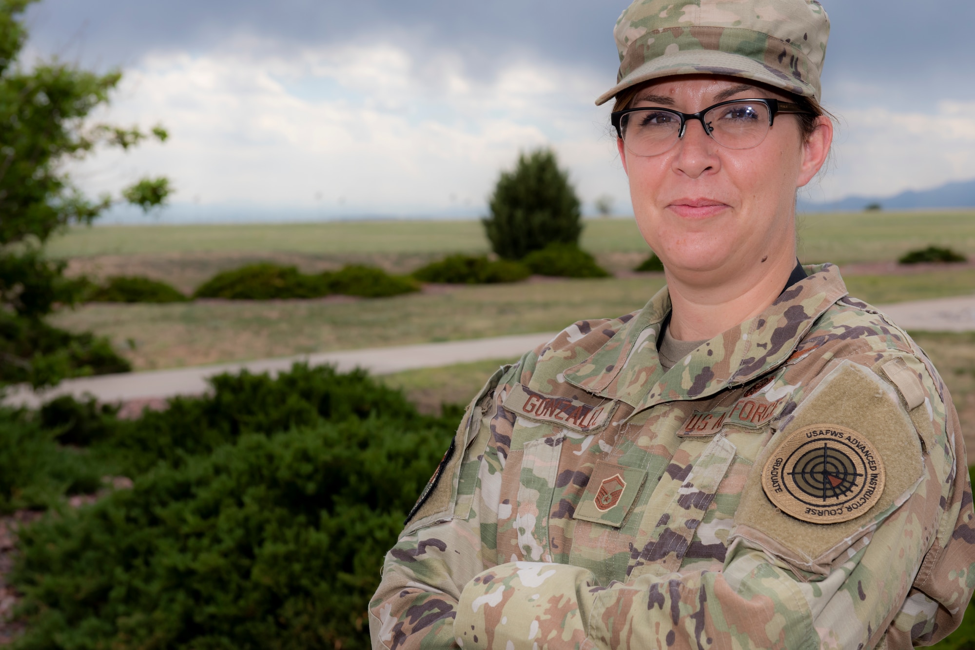 A woman stands outside with her arms folded.