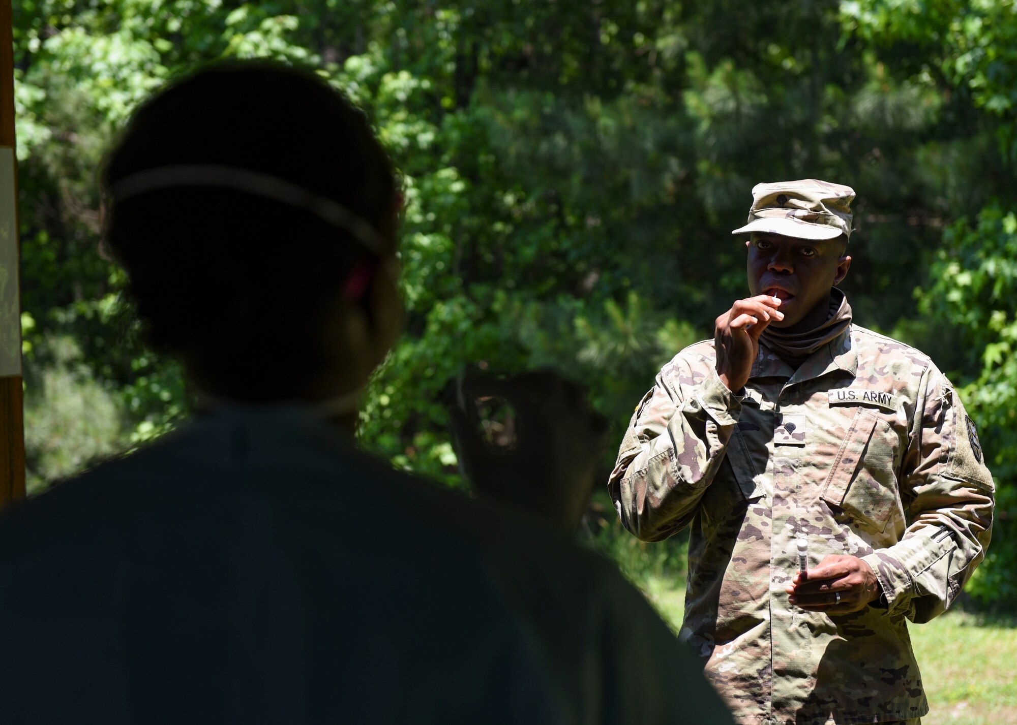 McDonald Army Health Center staff members conduct oral swab tests during a mass rapid COVID-19 testing at Joint Base Langley-Eustis, Virginia, June 3, 2020. The MCAHC members guided U.S. Army Soldiers through swab procedures while maintaining distance to ensure safe practices. (U.S. Air Force photo by Senior Airman Monica Roybal)