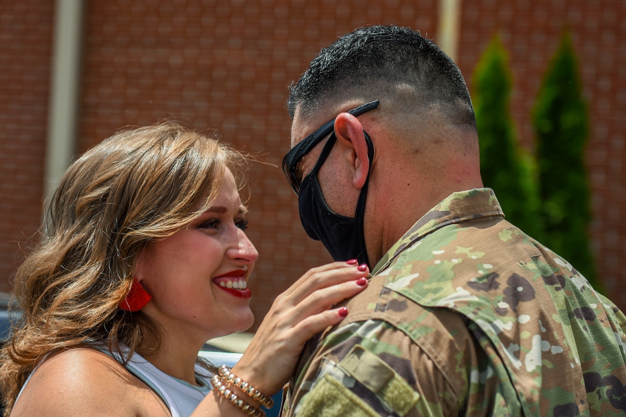 An airman hugs his spouse.