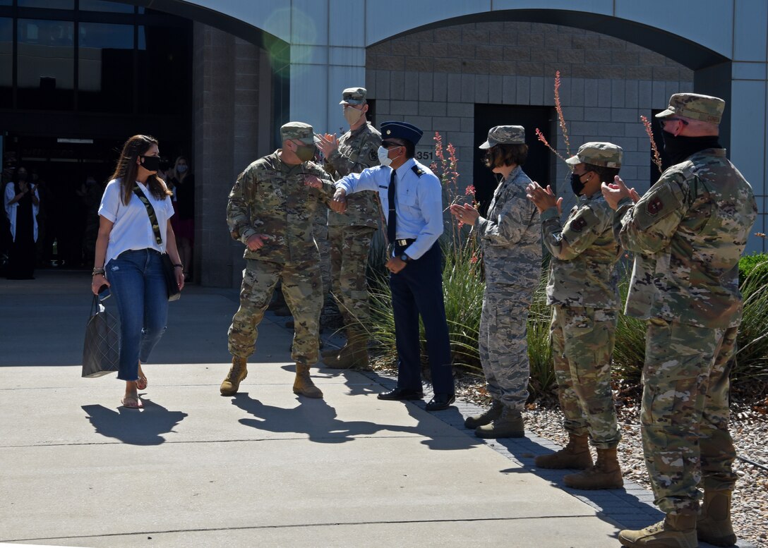 U.S. Air Force Col. Robert Ramirez, 17th Training Wing vice commander, elbow bump members of Goodfellow, while leaving the Norma Brown building for the last time during his time in station, before PCS-ing from Goodfellow Air Force Base, Texas, June 5, 2020. Members of the 17th TRW wore masks and followed social distancing procedures as Ramirez transitioned from Goodfellow to his gaining assignment in San Antonio, Texas, during the COVID-19 pandemic. (U.S. Air Force by Airman 1st Class Abbey Rieves)