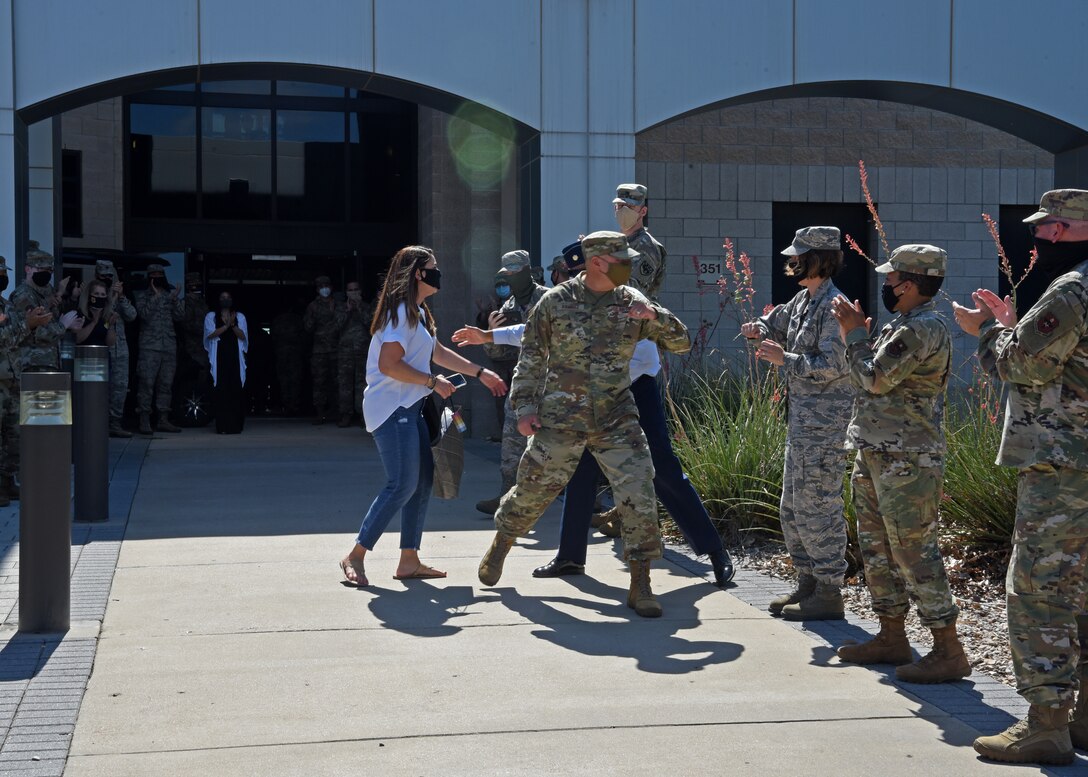 U.S. Air Force Col. Robert Ramirez, 17th Training Wing vice commander, elbow bump members of the 17th Medical Group, while leaving the Norma Brown building for the last time during his time in station, before PCS-ing from Goodfellow Air Force Base, Texas, June 5, 2020.Members of the 17th TRW wore masks and followed social distancing procedures as Ramirez transitioned from Goodfellow to his gaining assignment in San Antonio, Texas, during the COVID-19 pandemic.  (U.S. Air Force by Airman 1st Class Abbey Rieves)