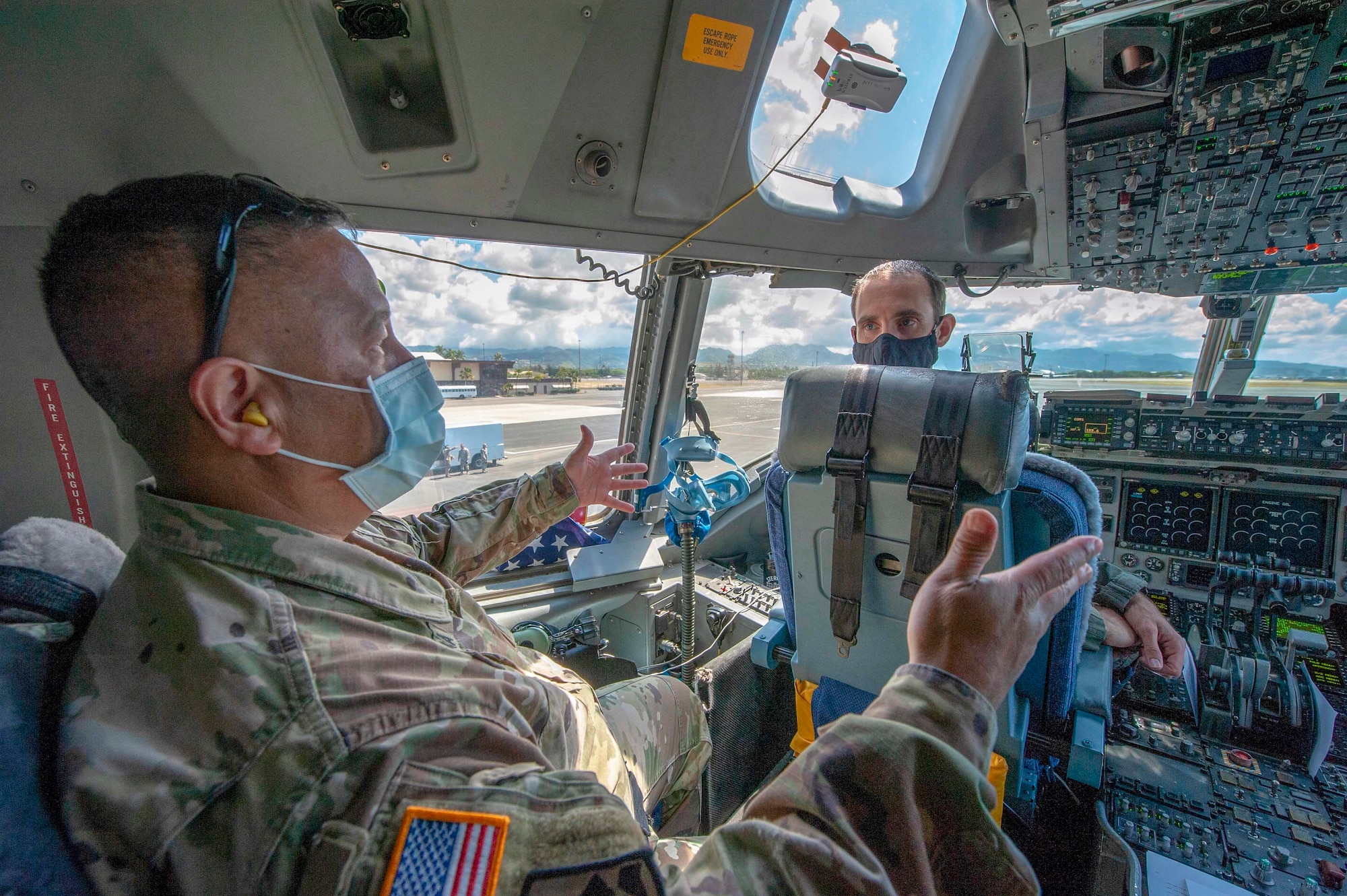 Major Gen. Kenneth S. Hara the adjutant general for the State of Hawaii and Lt. Col. Chris Skoutas, 535th Airlift Squadron pilot, discuss a flight path before taking off for a flyover of the Hawaiian Islands May 14, 2020', at Joint Base Pearl Harbor-Hickam. Hawaii.