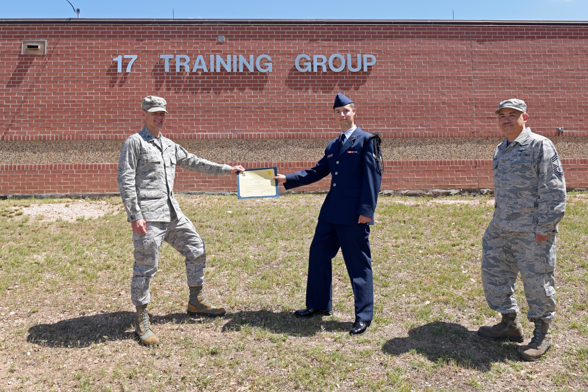 U.S. Air Force Col. Thomas Coakley, 17th Training Group commander, presents the 316th Training Squadron Student of the Month award to Airman 1st Class Jonathan Zamora, 316th TRS student, at Brandenburg Hall on Goodfellow Air Force Base, Texas, June 5, 2020. The 316th TRS’ mission is to conduct U.S. Air Force, U.S. Army, U.S. Marine Corps, U.S. Navy and U.S. Coast Guard cryptologic, human intelligence and military training. (U.S. Air Force photo by Senior Airman Zachary Chapman)