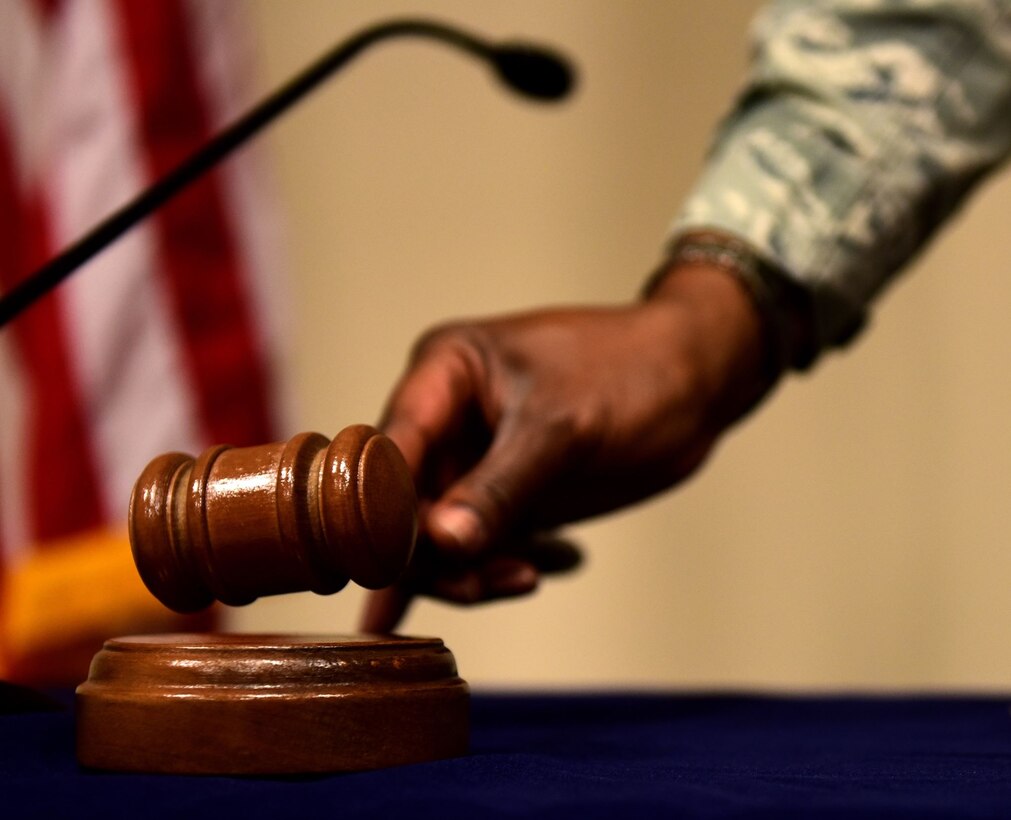 Airman sets down a gavel on a table.