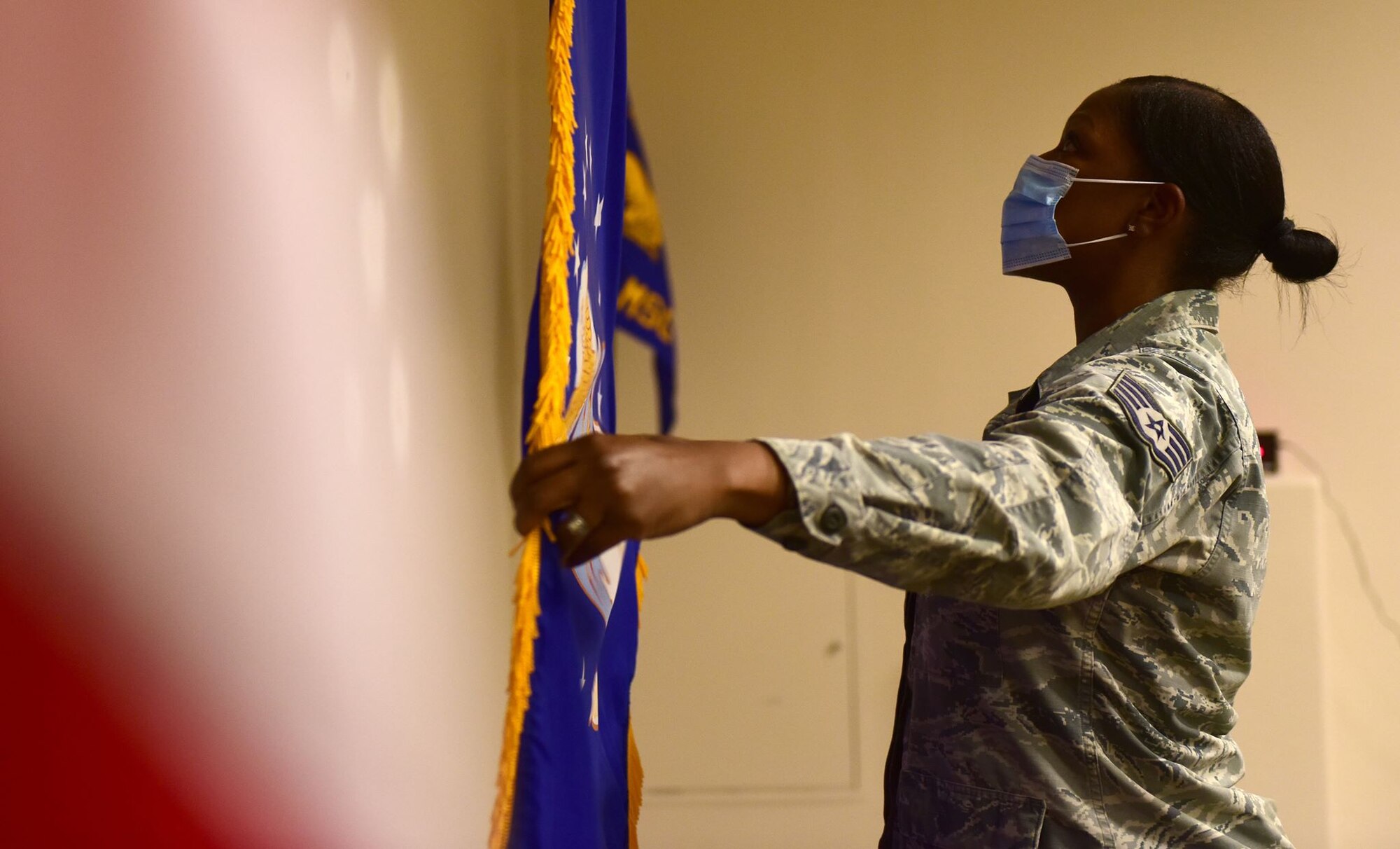 Staff Sgt. Tiffany pulls out the Air Force flag behind the United States flag.
