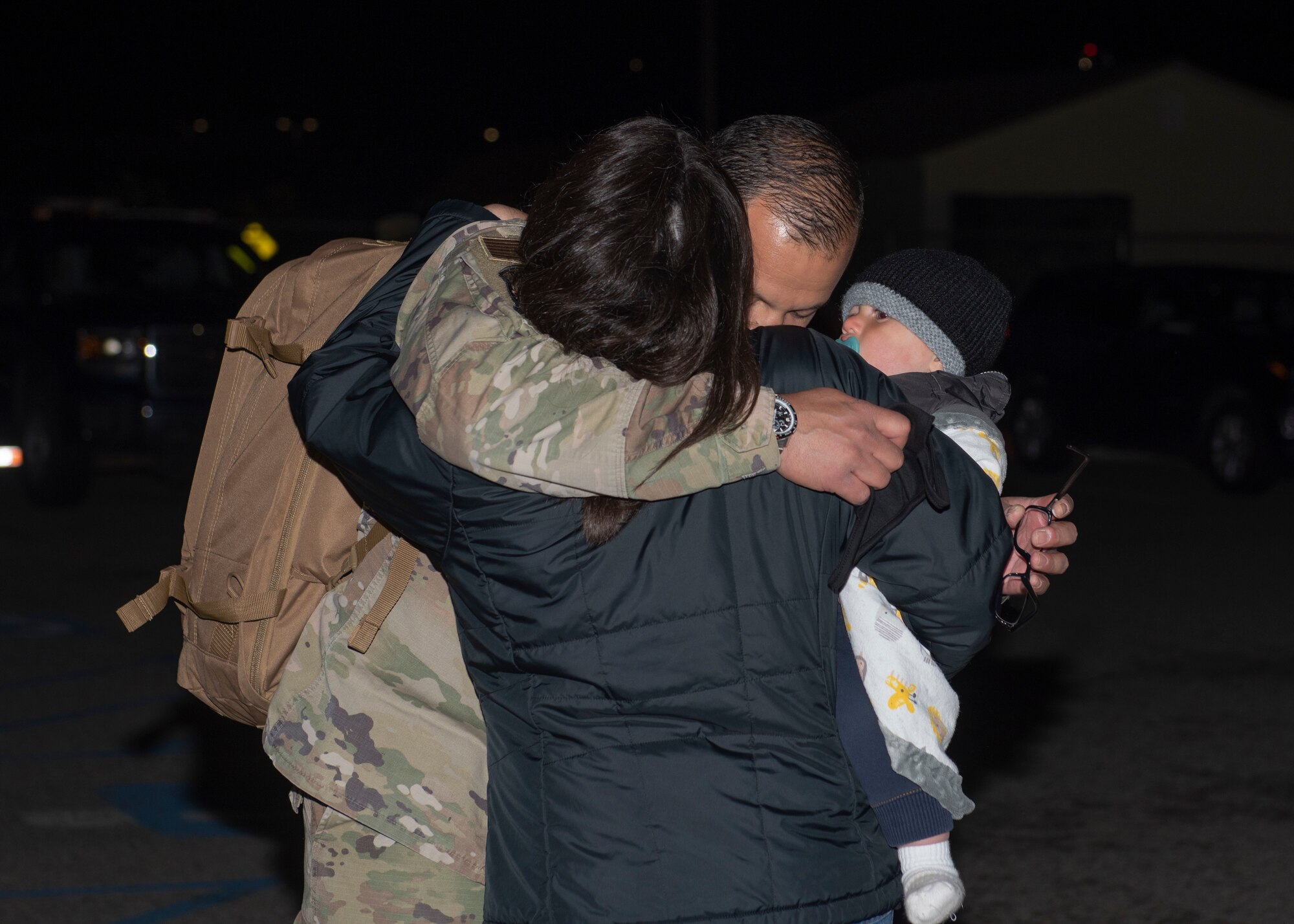 U.S. Air Force Maj. Jesus Burciaga, 726th Air Control Squadron director of operations, hugs his family, May 21, 2020, at Mountain Home Air Force Base, Idaho. The 726th Air Control Squadron returned from an eight month long deployment that was extended due to the COVID-19 pandemic. (U.S. Air Force photo by Airman 1st Class Natalie Rubenak)
