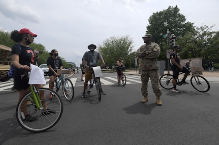 Army Capt. Macharia Davis, an intelligence officer with the District of Columbia Army National Guard’s, Headquarters and Headquarters Detachment, 74th Troop Command, talks with individuals taking part in one of many demonstrations and protests in Washington, D.C., Saturday, June 6, 2020, in the aftermath of the death of George Floyd. Guard members were on hand throughout the District manning traffic control points, aid stations and providing security.