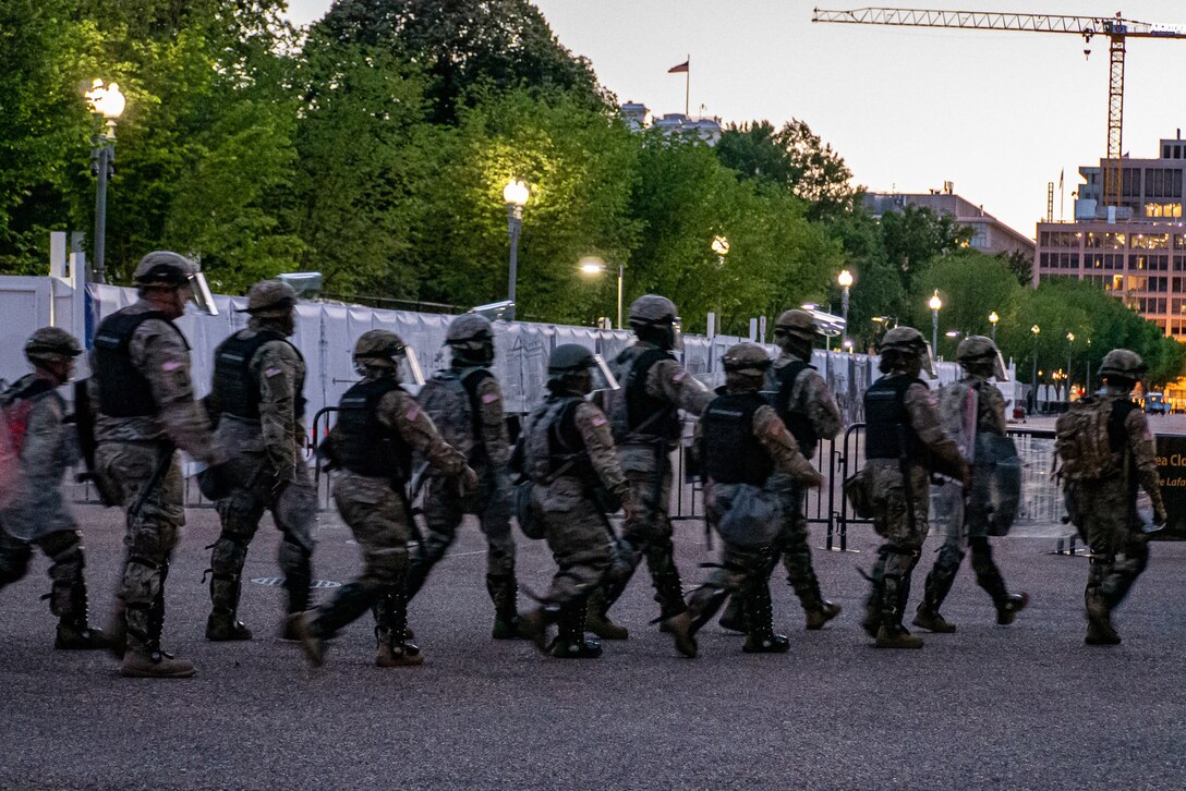 D.C. guardsmen file along a barricade.