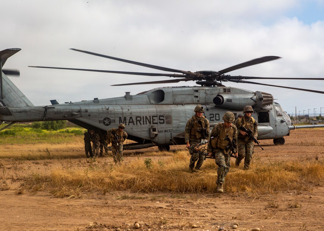 U.S. Marines with Weapons Company, Battalion Landing Team 1/4, 15th Marine Expeditionary Unit, move a simulated casualty from a CH-53E Super Stallion helicopter with Marine Medium Tiltrotor Squadron 164 (Reinforced), 15th Marine Expeditionary Unit, during a tactical recovery of aircraft and personnel training mission at Marine Corps Base Camp Pendleton, California, May 26, 2020. TRAP training prepares Marines with the knowledge and skills to recover isolated sensitive material and personnel in the event of a downed aircraft. (U.S. Marine Corps photo by Lance Cpl. Mackenzie Binion)