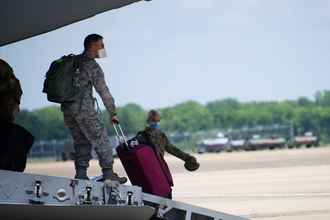 Airmen depart a C-17 Globemaster