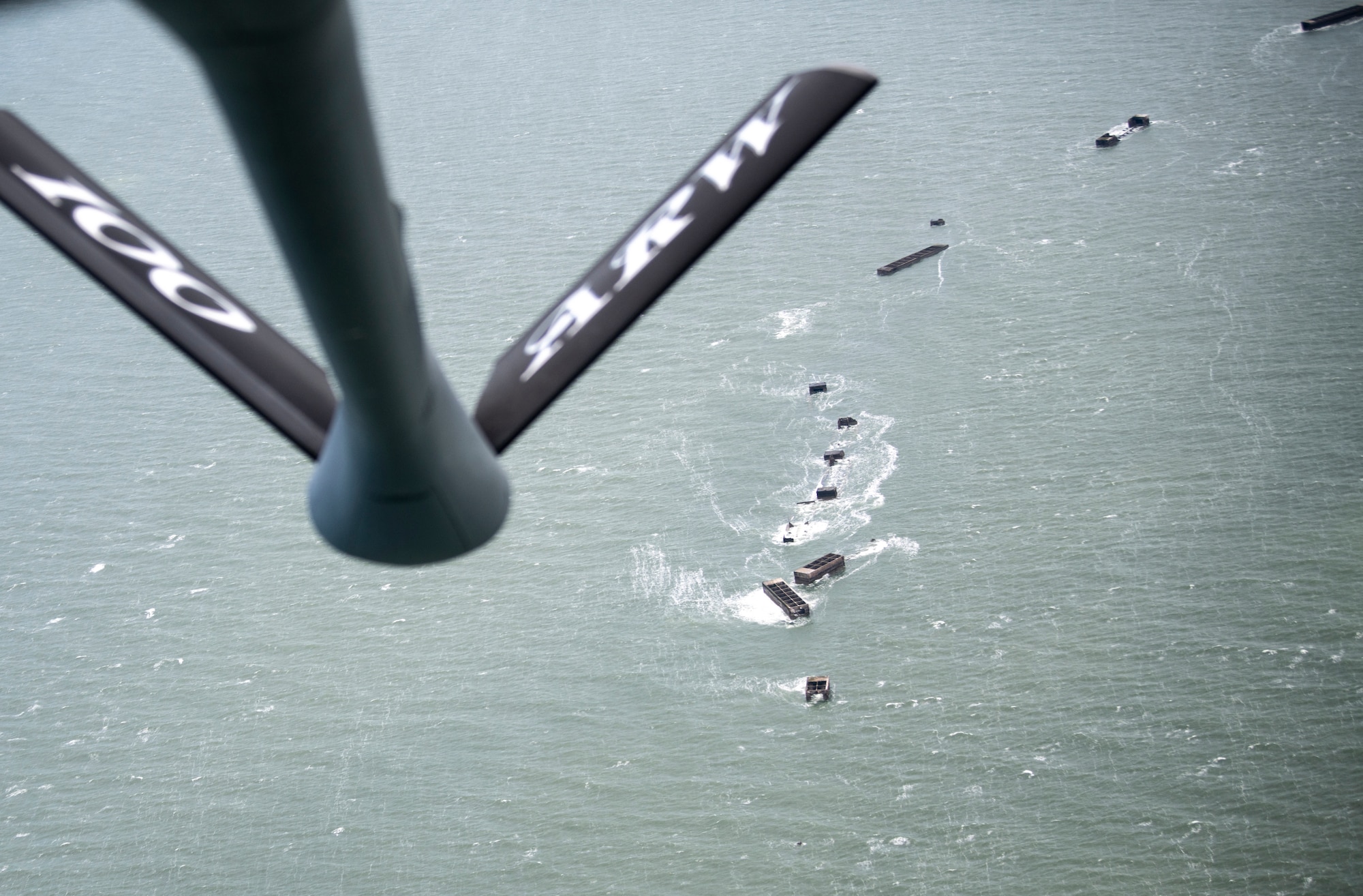 A KC-135 Stratotanker assigned to the 100th Air Refueling Wing, RAF Mildenhall, England, flies over Mulberry harbor during a flight supporting the 76th anniversary commemoration of D-Day off the French coast, June 6, 2020. D-Day reflects the strength of enduring relationships and proven partnerships. This historic relationship has allowed U.S. forces to remain ready and have the strategic access in Europe to accomplish high-priority missions with our European allies and partners. (U.S. Air Force photo by Tech. Sgt. Emerson Nuñez)