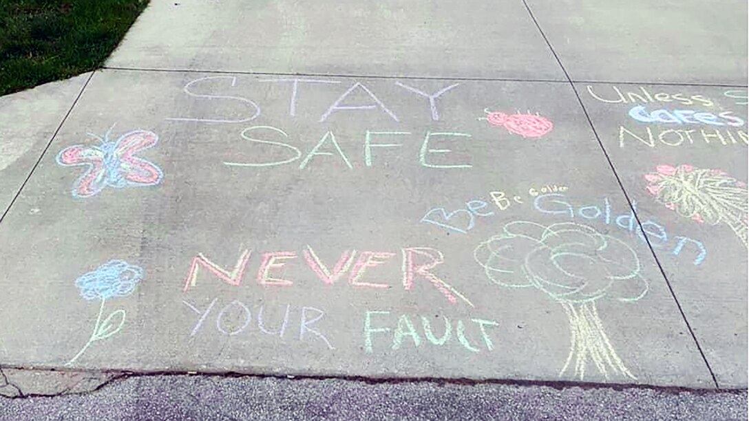Messages of support for sexual assault survivors written in chalk include "stay safe," and "never your fault."