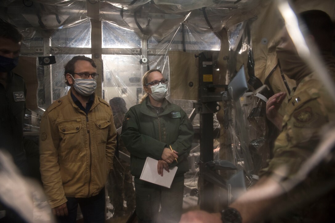 German air force medical professionals listen to a briefing from an Airmen assigned to 521st Air Mobility Operations Wing during a COVID-19 Transport Isolation System tour.