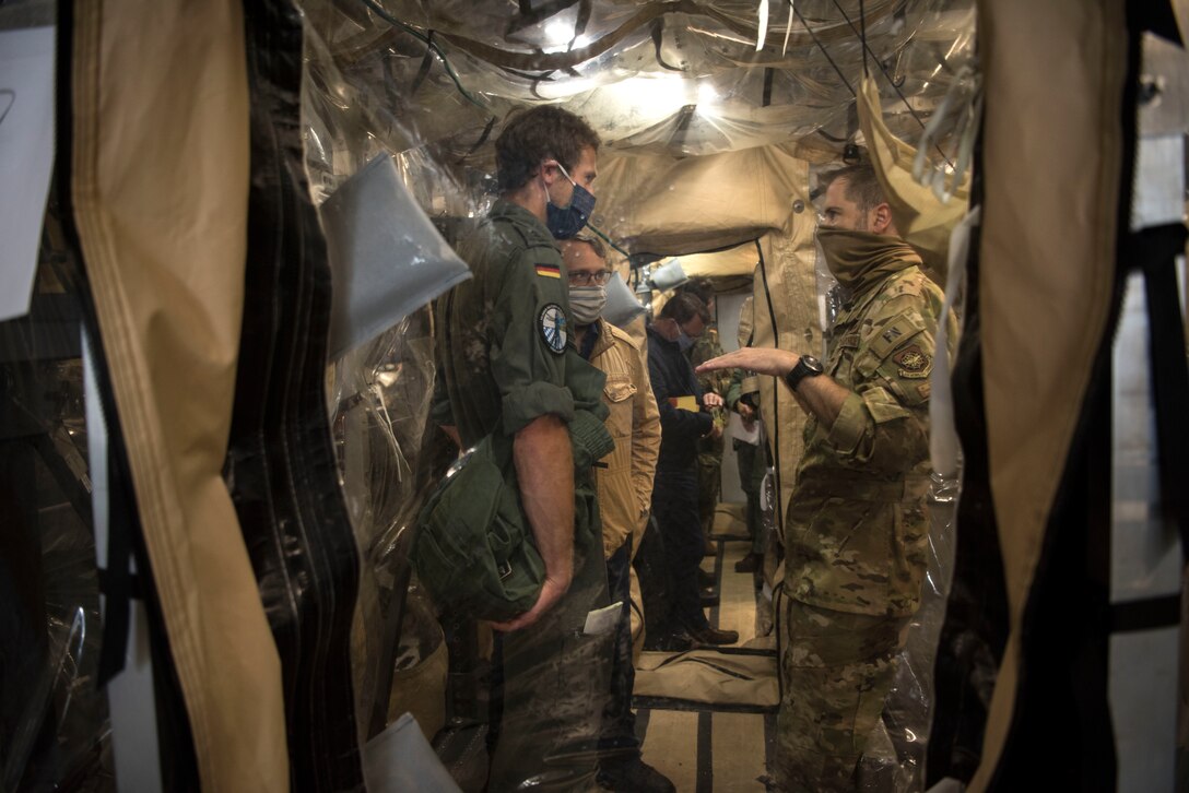 U.S. Air Force Maj. Sean Smith, 10th Expeditionary Aeromedical Evacuation Flight aeromedical evacuation operations team officer in charge, gives a briefing to medical professionals from the German air force onboard a U.S. Air Force C-17 Globemaster III aircraft.