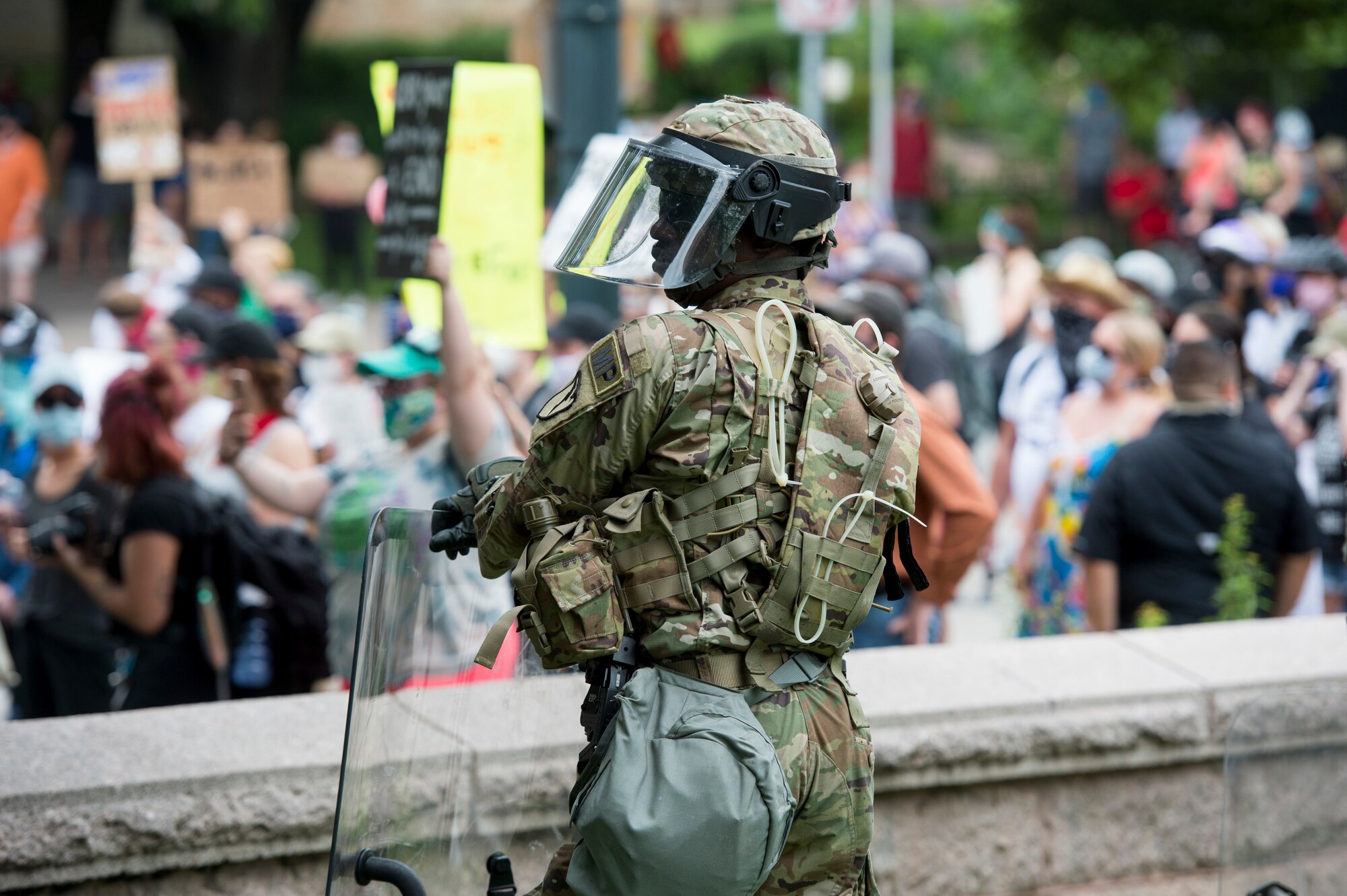 A military police officer assigned to the Texas National Guard watches over protesters during a peaceful demonstration in Austin, Texas, May 31, 2020. While community members exercised their 1st Amendment rights, Texas National Guard assisted local law enforcement with protecting life and property. (Photo by Charles E. Spirtos)
