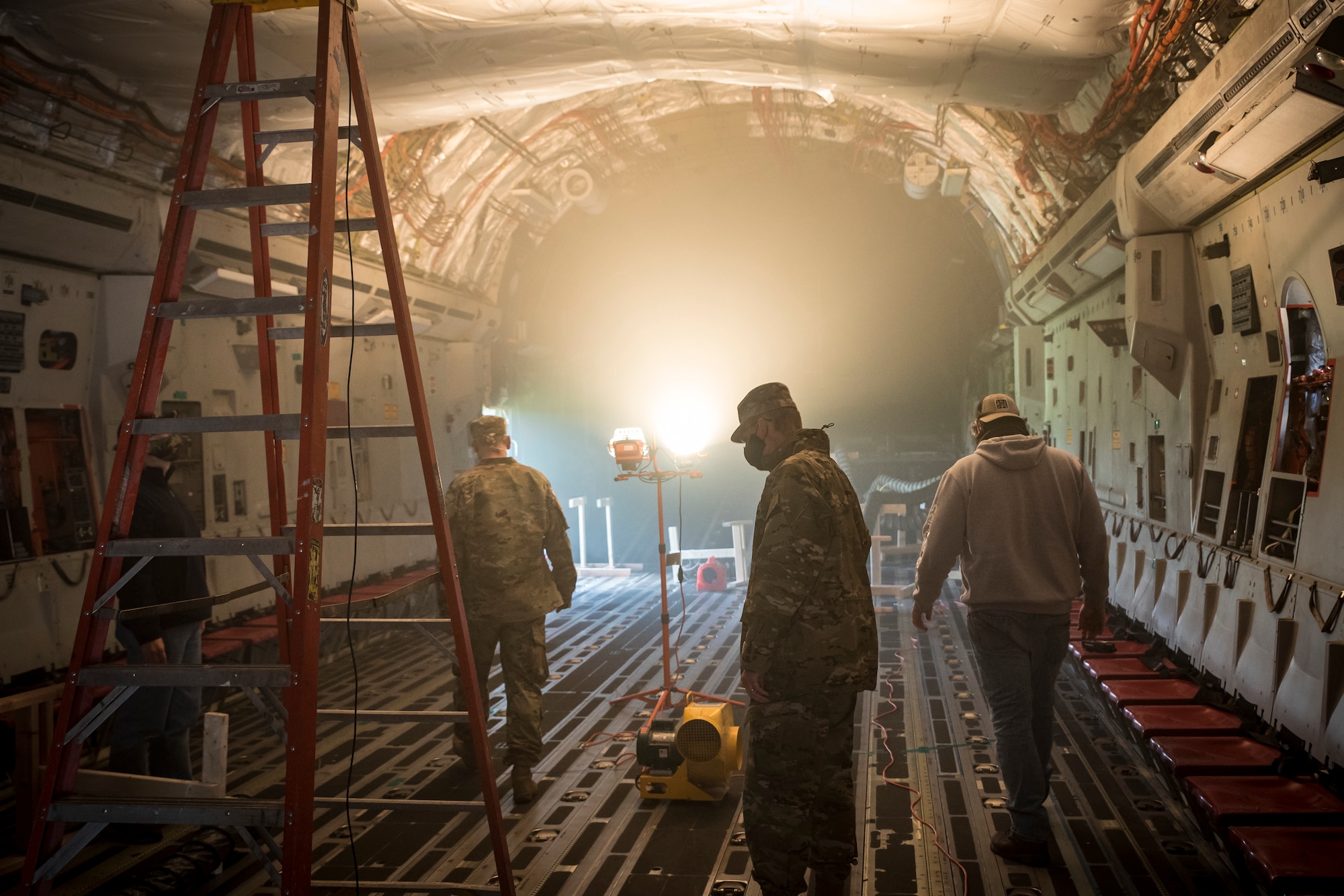 Air Force Research Laboratory team members look over a C-17 used to investigate the ability of ground heaters to raise interiors to temperatures sufficient to kill the COVID-19 virus.This test is part of an overall effort to demonstrate the effectiveness of using common equipment to disinfect aircraft quickly and easily at virtually any military installation. (U.S. Air Force photo/Richard Eldridge)