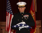 Col. Eric S. Livingston, special project officer, Marine Corps Logistics Command, receives an American Flag during his retirement ceremony at the Base Chapel on Marine Corps Logistics Base Albany, Georgia, June 5. Livingston served more than 33 years in the Marine Corps.