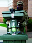 Sgt. Quintin Shine, a noncommissioned officer with Assembly Area Lions, is checking the water levels on one of the hand-washing stations that are set up for Soldiers. Shine is assisting many National Guard members stationed at hotels to keep them from infecting their families during the pandemic.