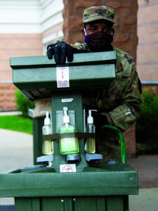 Sgt. Quintin Shine, a noncommissioned officer with Assembly Area Lions, is checking the water levels on one of the hand-washing stations that are set up for Soldiers. Shine is assisting many National Guard members stationed at hotels to keep them from infecting their families during the pandemic.