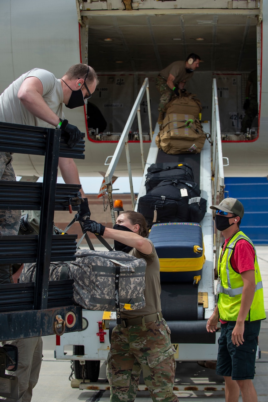 Airmen load cargo from a truck into a transport jet’s cargo bay.