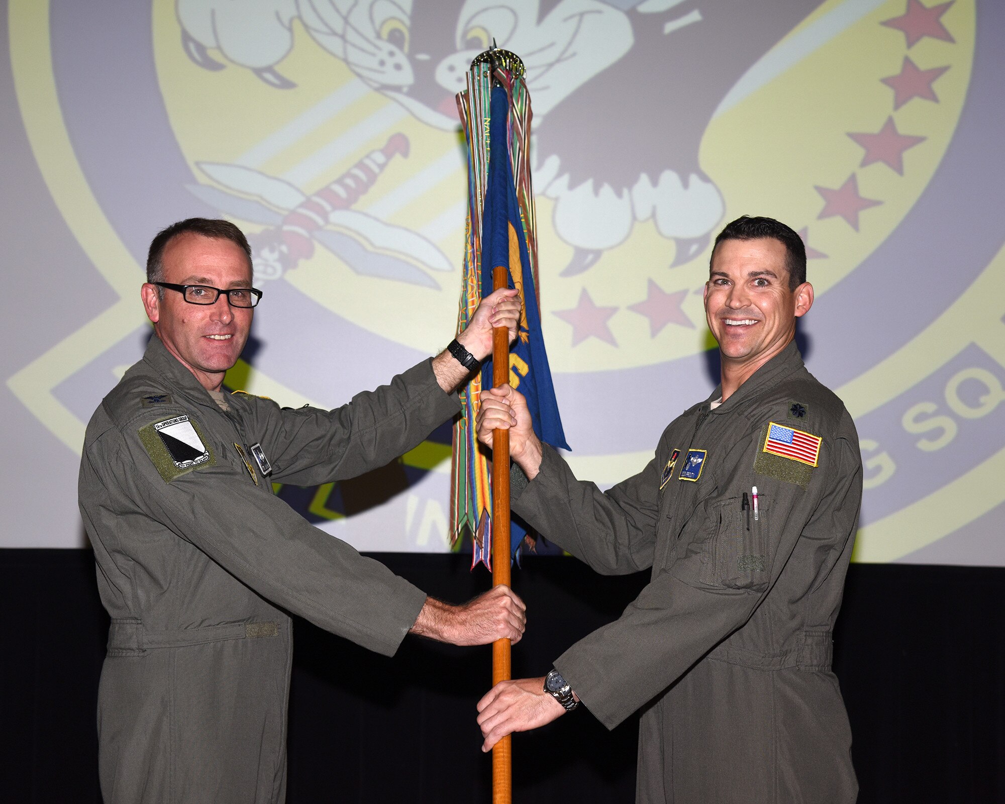 Col. Tom McElhinney, 14th Operations Group commander, hands Lt. Col. Nelson Prouty, 48th Flying Training Squadron commander, the 48th FTS guidon at the change of command ceremony May 21, 2020, on Columbus Air Force Base, Miss. The 48th FTS conducts the tanker and airlift track of specialized undergraduate pilot training where students receive a minimum of 159 hours of flight instruction in the T-1A Jayhawk. (U.S. Air Force photo by Sharon Ybarra)