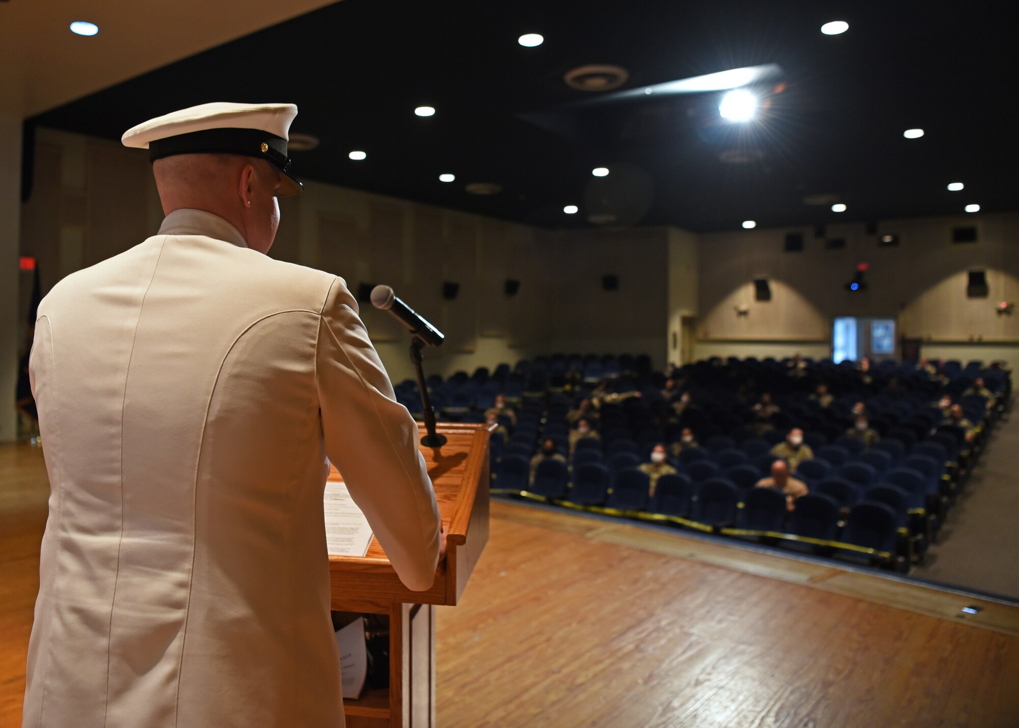 U.S. Navy Chief Petty Officer Tyler Stull, The Center for Information Warfare Training division leading chief petty officer, addresses the audience at The Battle of Midway remembrance ceremony in the base theater, on Goodfellow Air Force Base, Texas, June 5, 2020. Due to the health protection condition level in bravo, Sailors followed strict hygiene measures and kept a six feet distance from others, assisted by caution tape. (U.S. Air Force photo by Airman 1st Class Abbey Rieves)