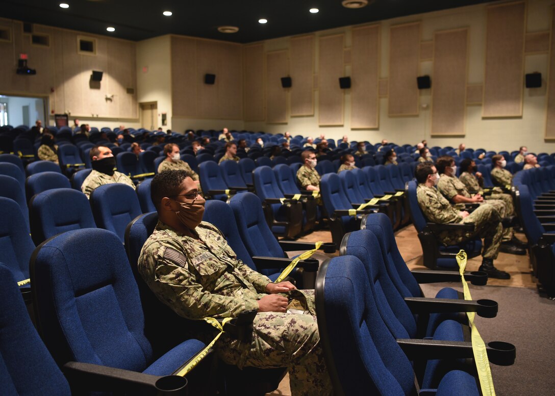 U.S. Navy members of The Center for Information Warfare Training sit in a socially distant formation at The Battle of Midway remembrance ceremony in the base theater, on Goodfellow Air Force Base, Texas, June 5, 2020. Due to the health protection condition level in bravo, Sailors followed strict hygiene measures and kept a six feet distance from others, assisted by caution tape. (U.S. Air Force photo by Airman 1st Class Abbey Rieves)