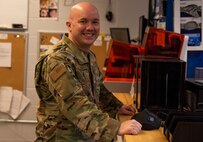 An Airman stands at a work station used to create Nasopharyngeal swabs for COVID-19 testing.