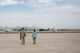 A photo of a CBP agent and Airman walking on the flight line