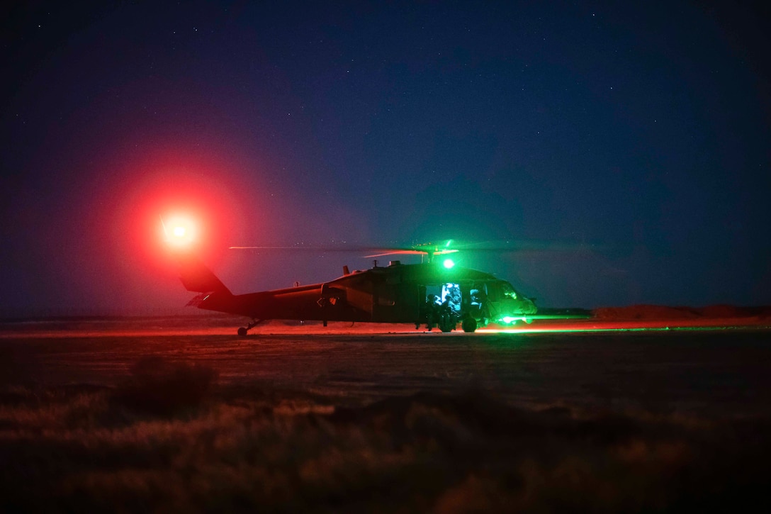 An Army helicopter prepares to take off at night.