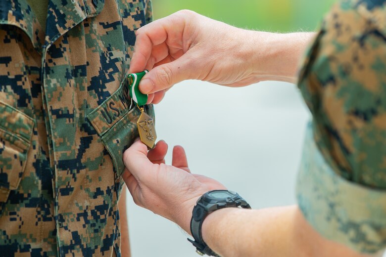 U.S. Marine Corps Lt. Col. Christopher Conner, the commanding officer of Alpha Company, 2nd Light Armored Reconnaissance Battalion, 2nd Marine Division, pins a Navy and Marine Corps Commendation Medal on Cpl. Matthew T. Ubl, a light armored vehicle repair technician with Alpha Co., 2nd LAR, on Camp Lejeune, North Carolina, June 4, 2020. Ubl received a NAVCOMM for his efforts executing cardiopulmonary resuscitation for 15 minutes on an unknown, unconscious civilian, which contributed to saving the man’s life.  (U.S. Marine Corps photo by Sgt. Stormy Mendez)