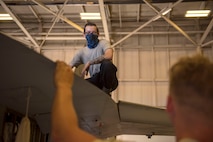 Airman 1st Class Gabriel Leal, 31tth Aircraft Maintenance Unit avionics journeyman, smiles as he speaks with Senior Airman Brian Raatz, 311th AMU F-16 Viper crew chief, June 4, 2020, on Holloman Air Force Base, N.M. The Airmen are replacing 11 wire harnesses and have been working on the project since early May 2020. (U.S. Air Force photo by Staff Sgt. Christine Groening)